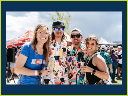 A group of three people happily posing for a photograph during an outdoor gathering.