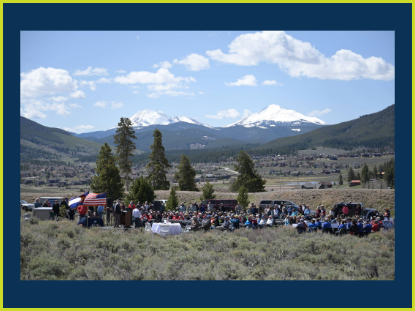 People unite in front of majestic mountains, enjoying the scenic view and each other's company.