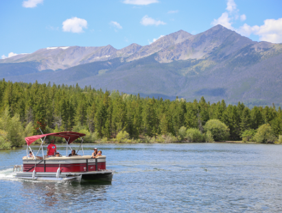 A small boat gently floating on calm water under a clear blue sky.