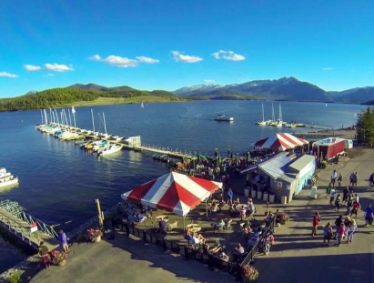 Aerial view of a marina bustling with people and various boats docked along the water.