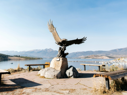 A statue of an eagle with wings outstretched perched on a bench, symbolizing freedom and strength